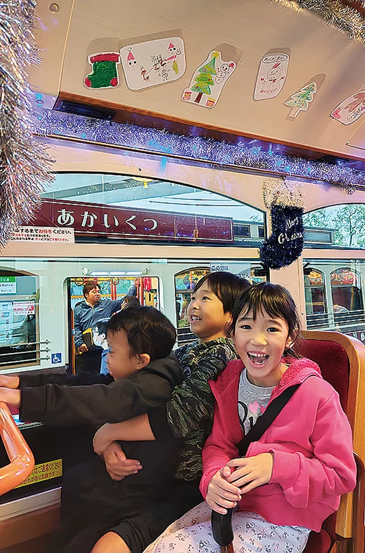 イルミネーション装飾を施したバスの車内ではしゃぐ子どもたち（走行前）