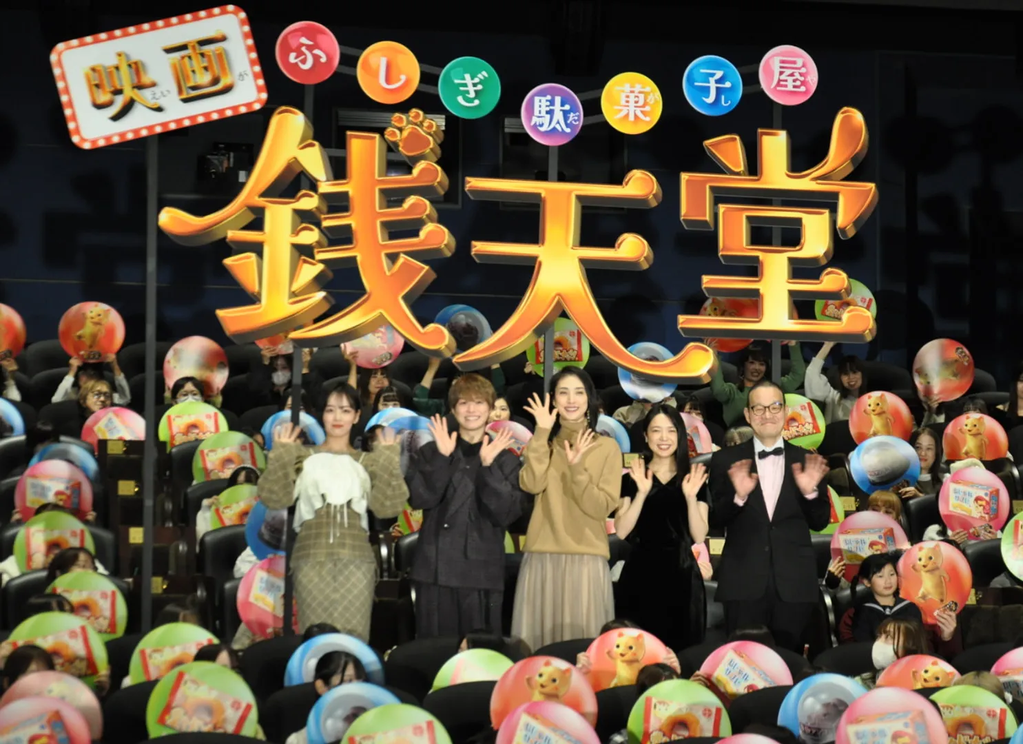銭天堂の駄菓子のパネルを持った観客と記念撮影（左から伊原さん、大橋さん、天海さん、上白石さん、中田監督）