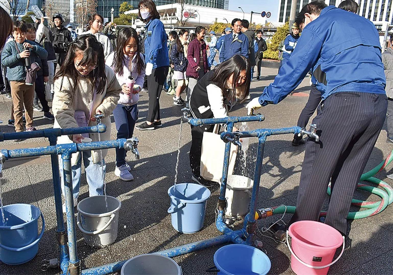 タンクからくみ上げた水をボトルに入れる児童
