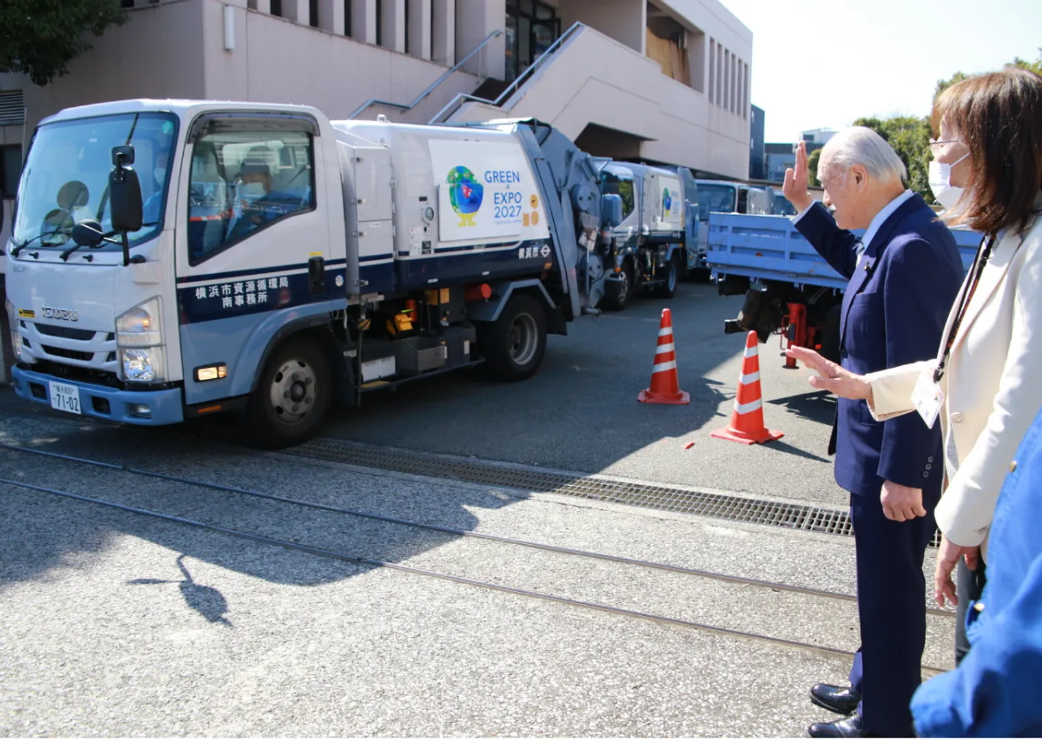 午後の収集に向かう収集車を見送る吉井会長ら