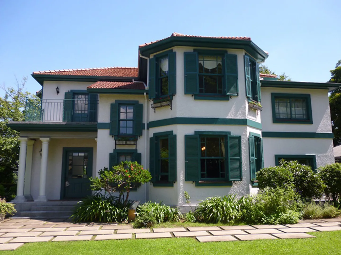 緑の窓枠、白い壁、オレンジ色のフランス瓦の屋根が美しい