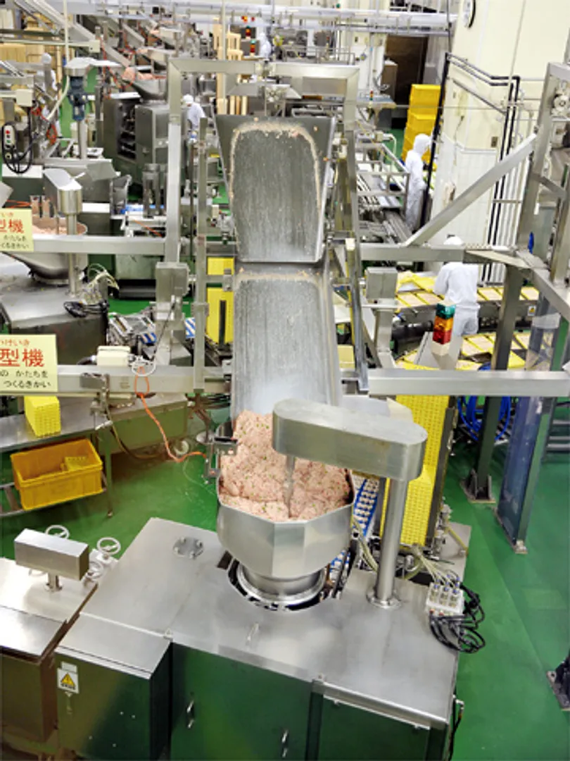 シウマイを成型する成型機。空中搬送台車が各成型機の具材の量をチェックし「シウマイのあん」を補充する