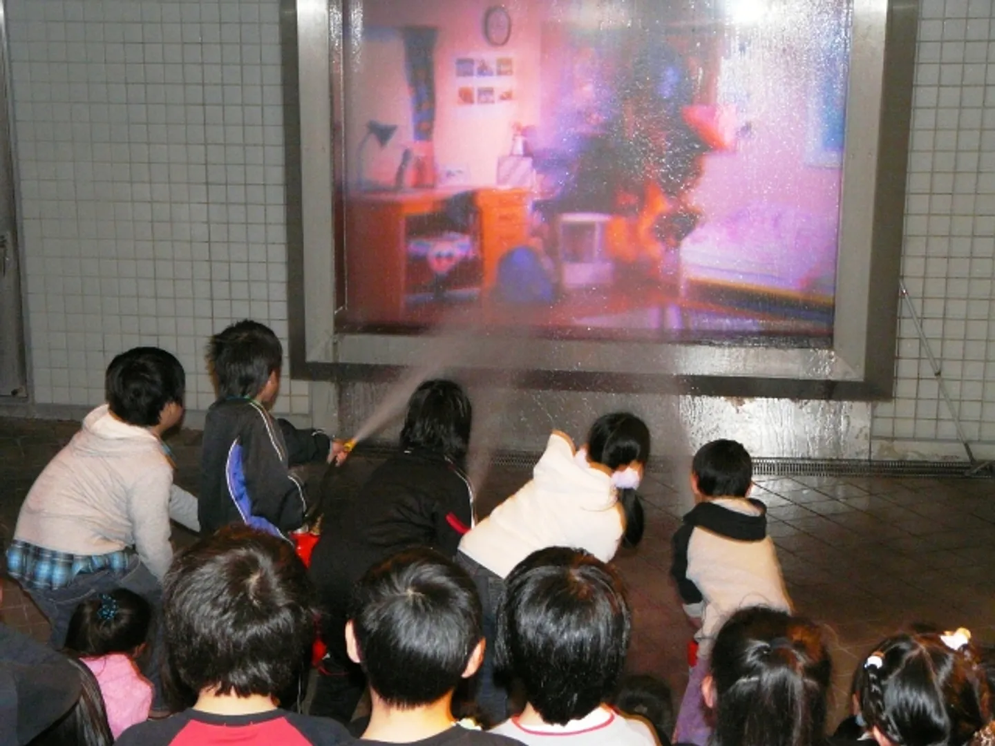 スクリーンに映し出された火災を消火器を使って消火する体験ができる