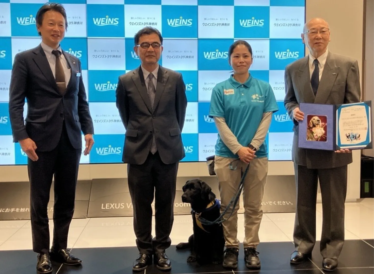 感謝状贈呈式にて。写真左から、ウエインズトヨタ神奈川の竹崎裕視執行役員、西村理事、ファシリティドッグ候補犬・エイミーちゃんとトレーナーの平沢佳奈さん 、宮原会長（提供写真）