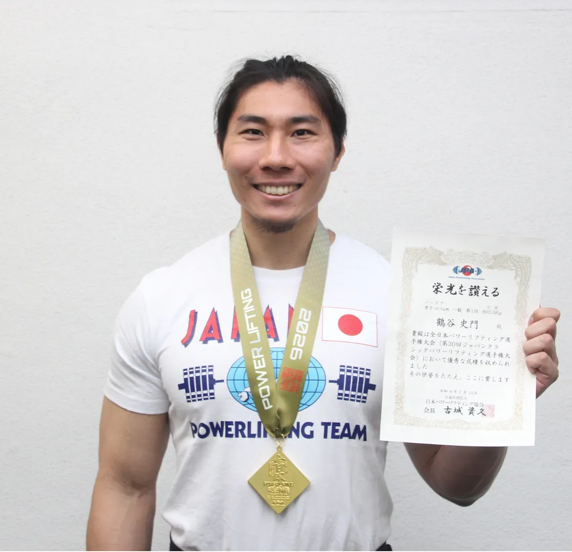 全日本選手権大会に優勝し、表彰状と金メダルを持ち、笑顔の鶴谷さん