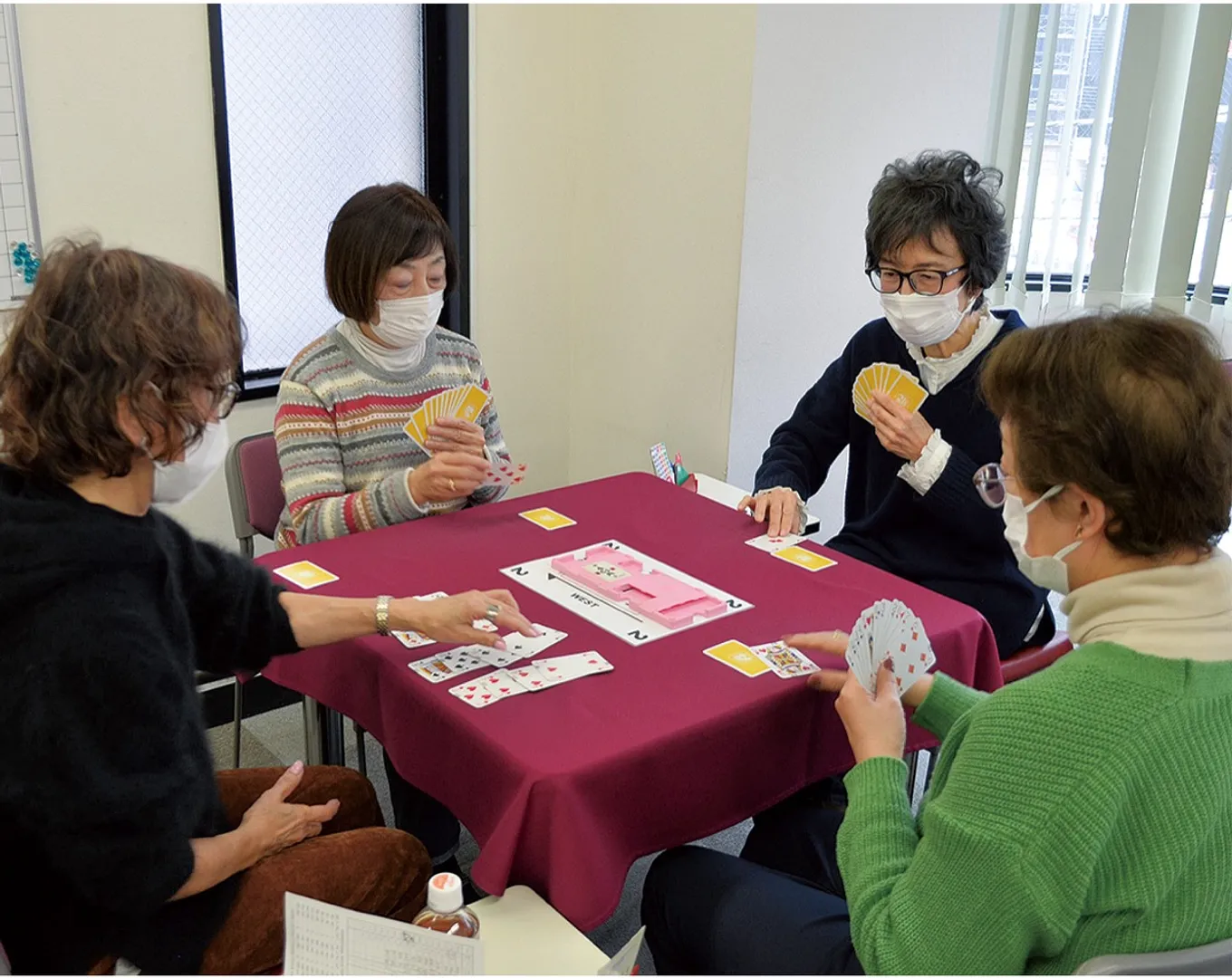 真剣な表情でテーブルを囲む参加者たち。ゲーム終了後の反省会でのおしゃべりも楽しみの一つだ