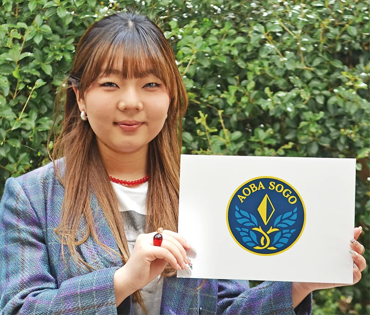 新校章を掲げる田邉さん