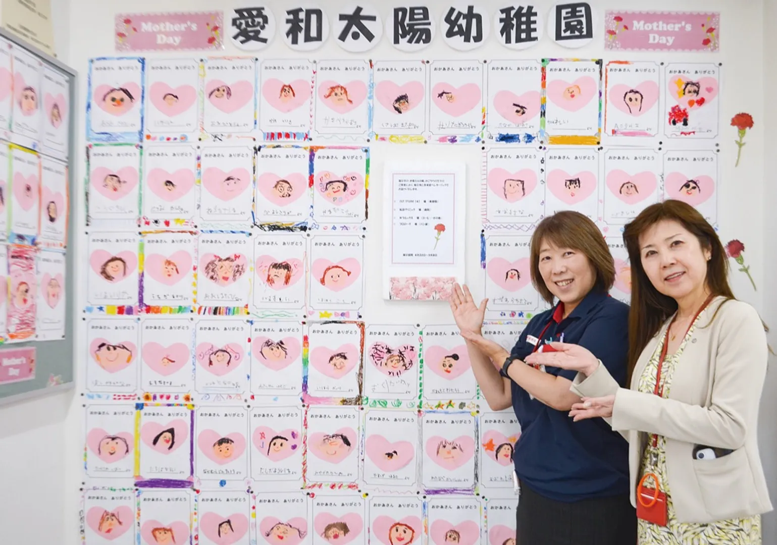 壁一面を彩る似顔絵と局員ら（右が武田局長）