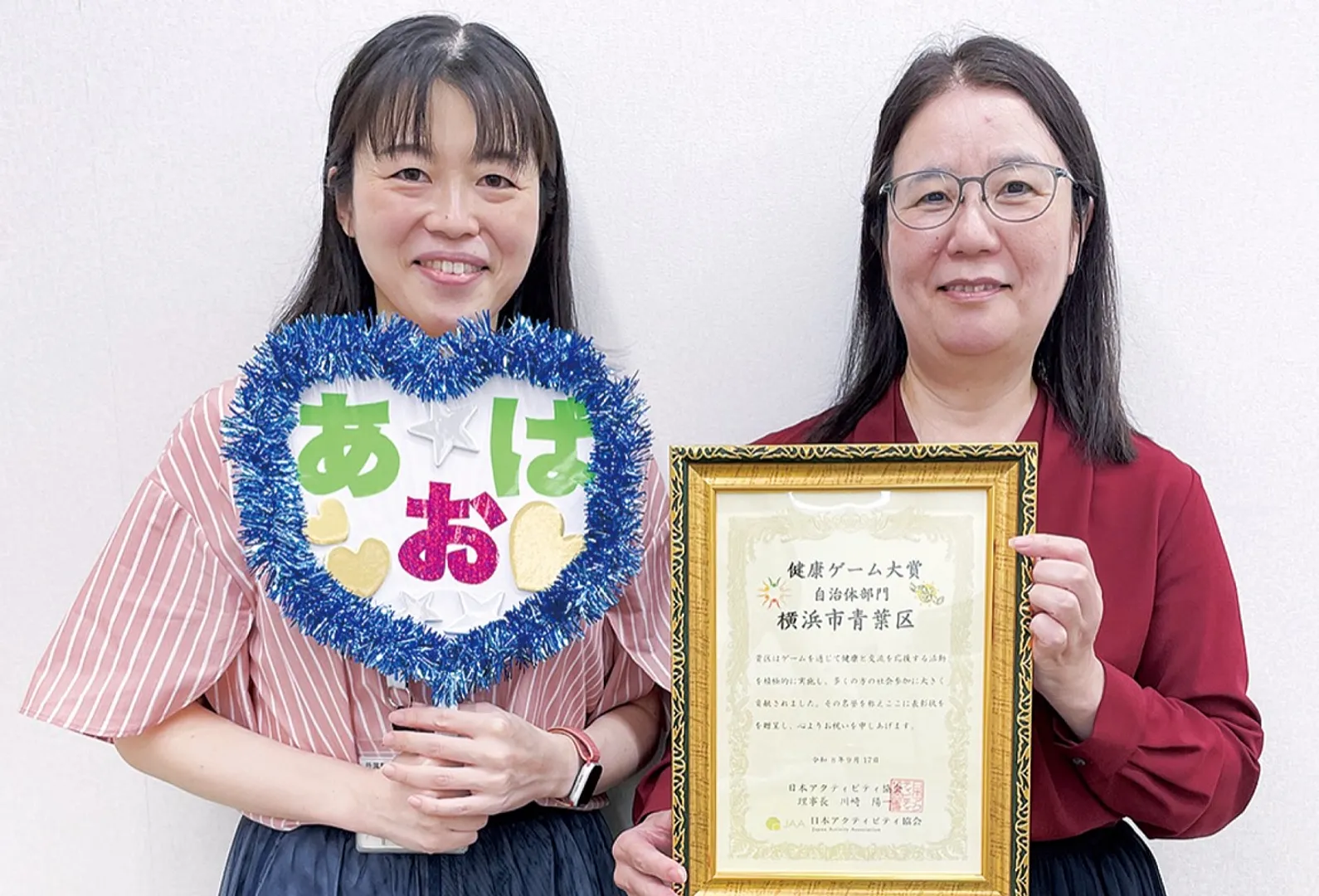 賞状を持つ同課の武井課長（右）と山本麻依子係長