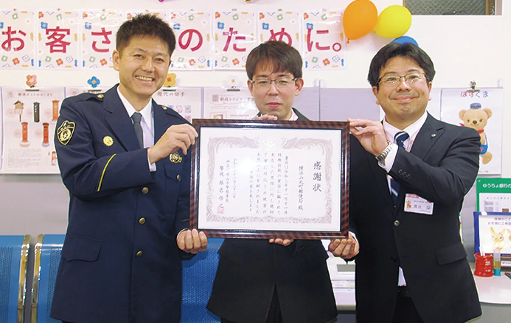 椎名署長（左）から感謝状を受け取る土門（中央）さんと清水局長