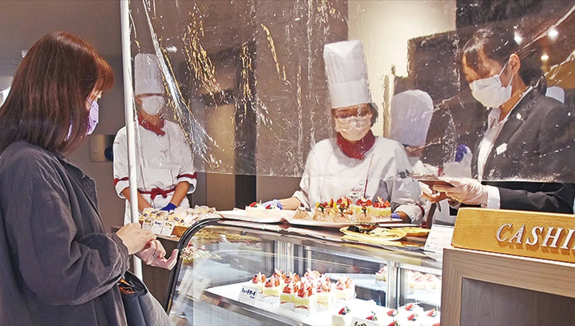 自ら作ったケーキを販売する学生たち