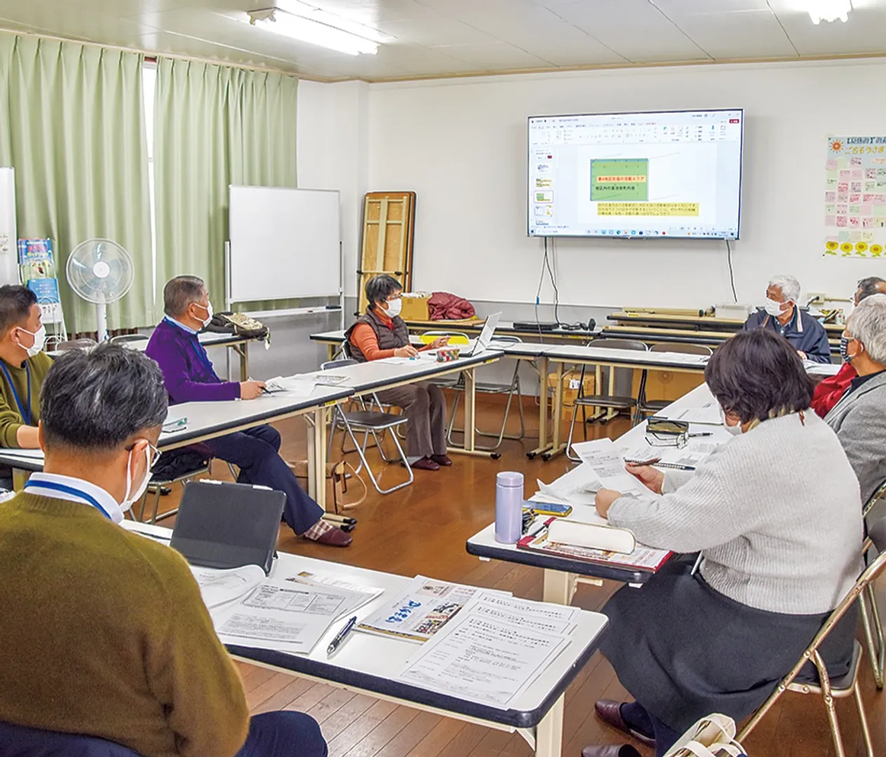 泉区からの視察に地区社協の活動を説明する米岡会長（左から４人目）