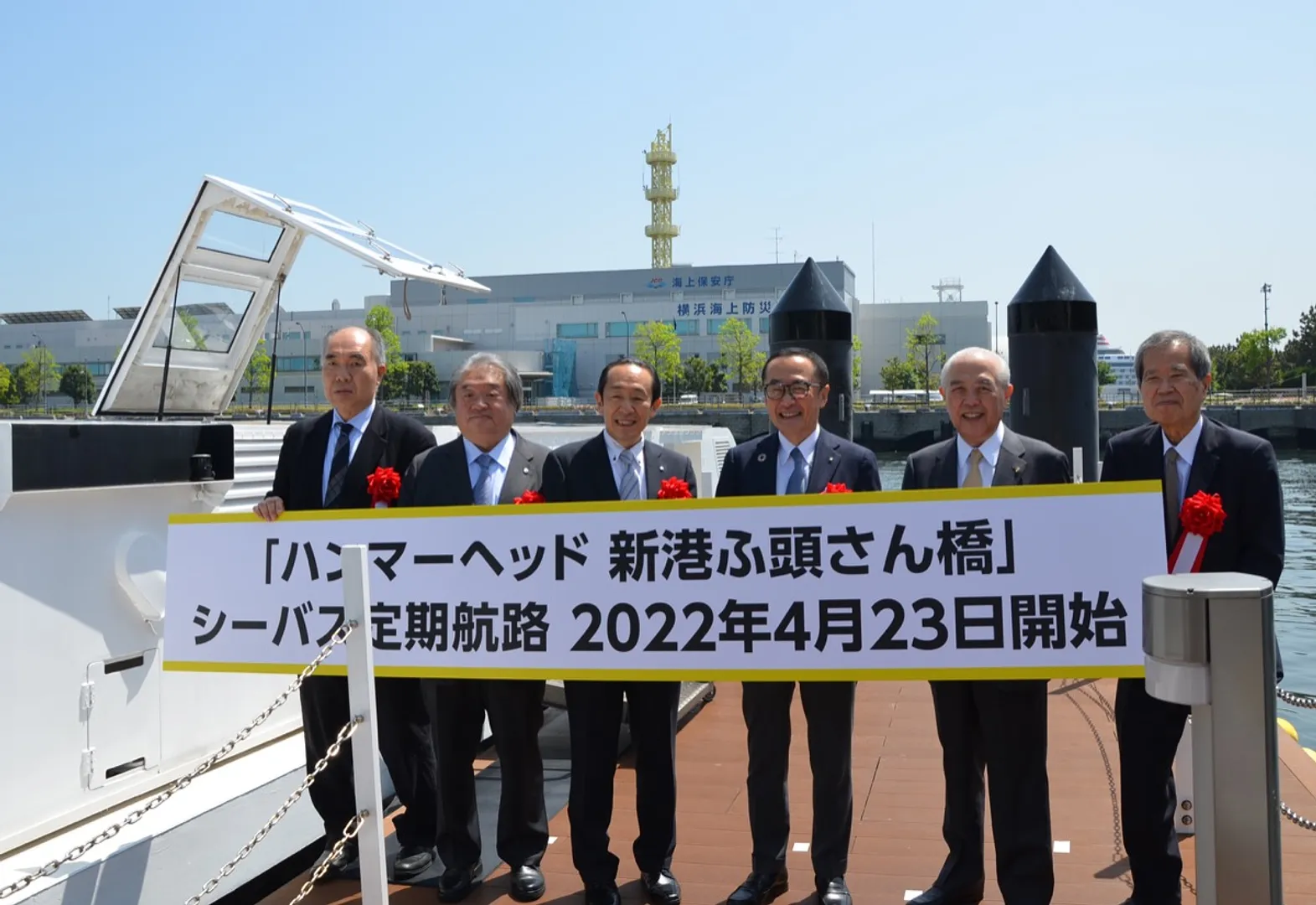 横浜ハンマーヘッド前の新港ふ頭さん橋でポートサービスの齊藤社長（左）や新港ふ頭客船ターミナルの岡田社長（中央左）、関係者らが門出を祝った