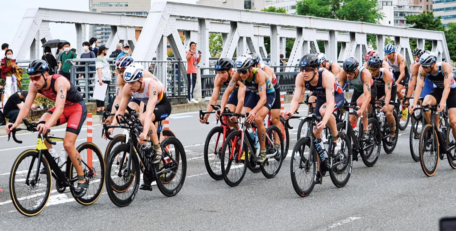 自転車で新港橋を渡る男子トライアスロンの出場者ら