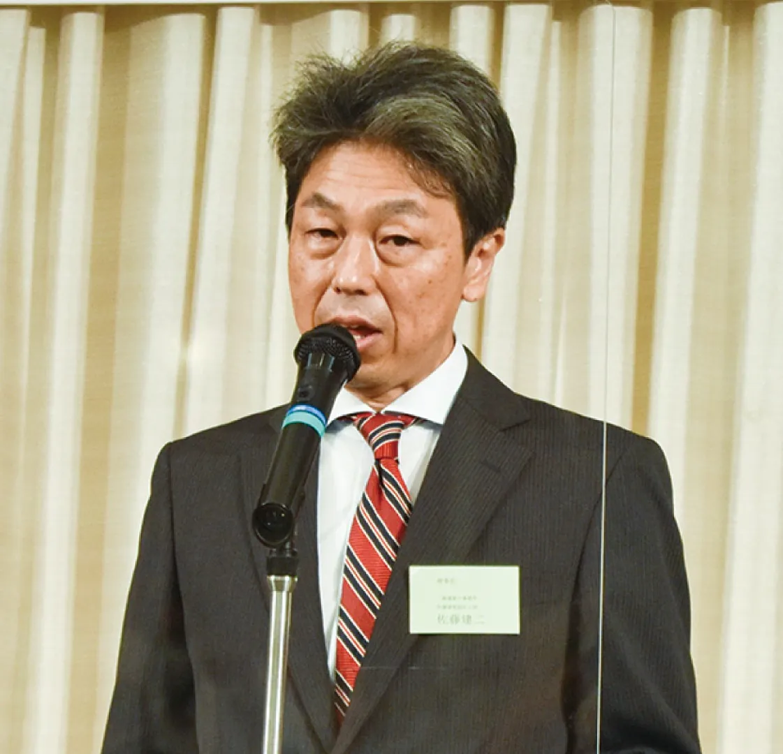 あいさつする佐藤理事長