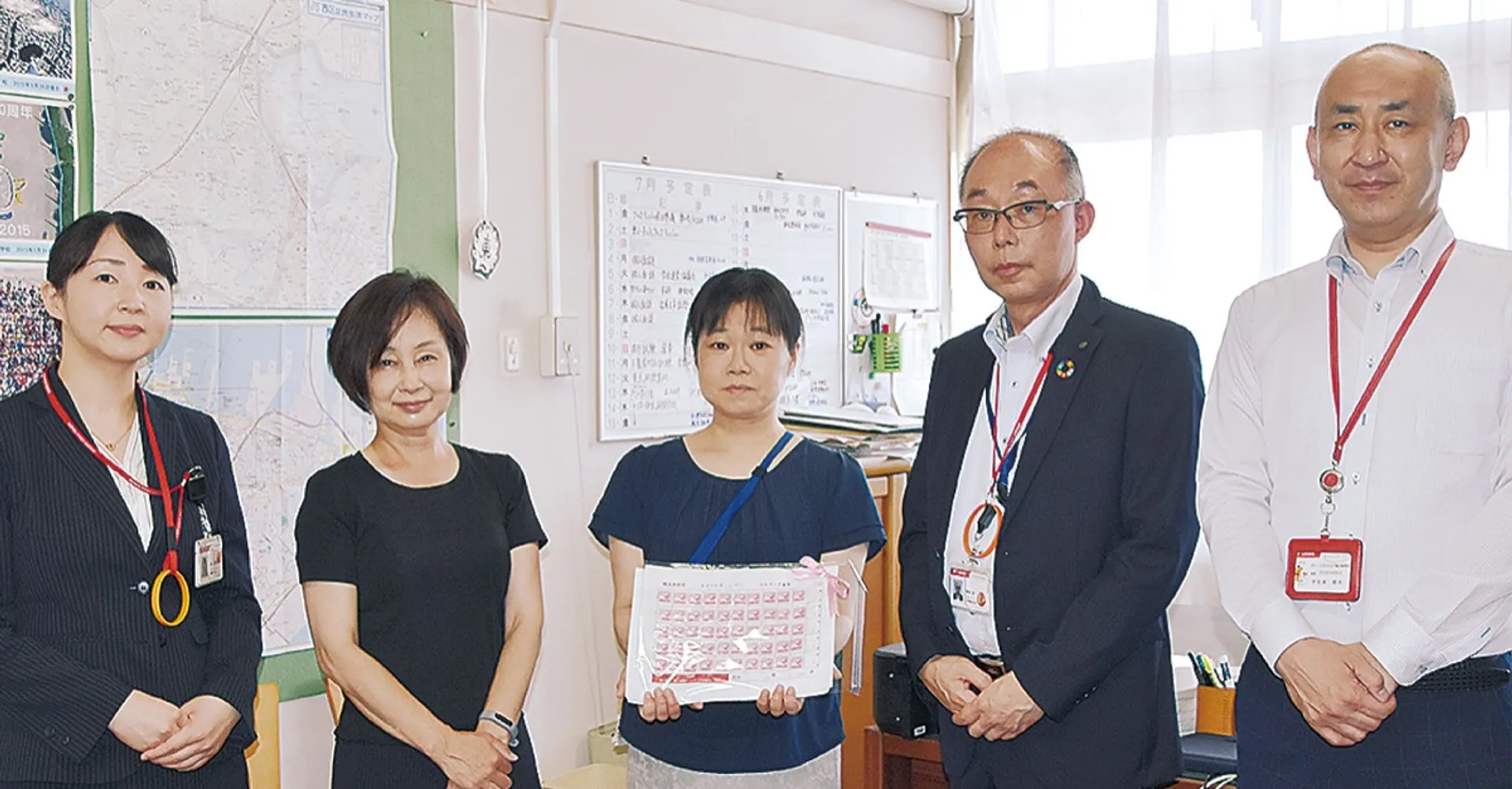 寄付されたベルマークを手にする東小の保科校長（中央）と西区内の郵便局長ら