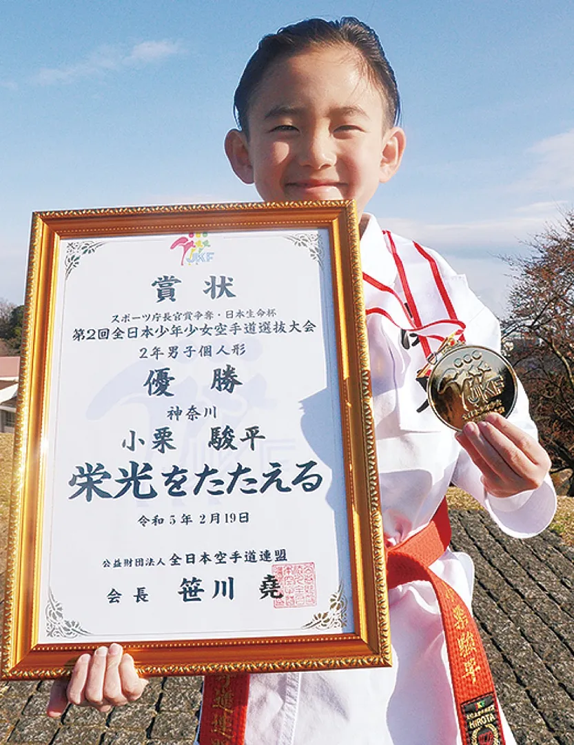 賞状と金メダルを持つ小栗君