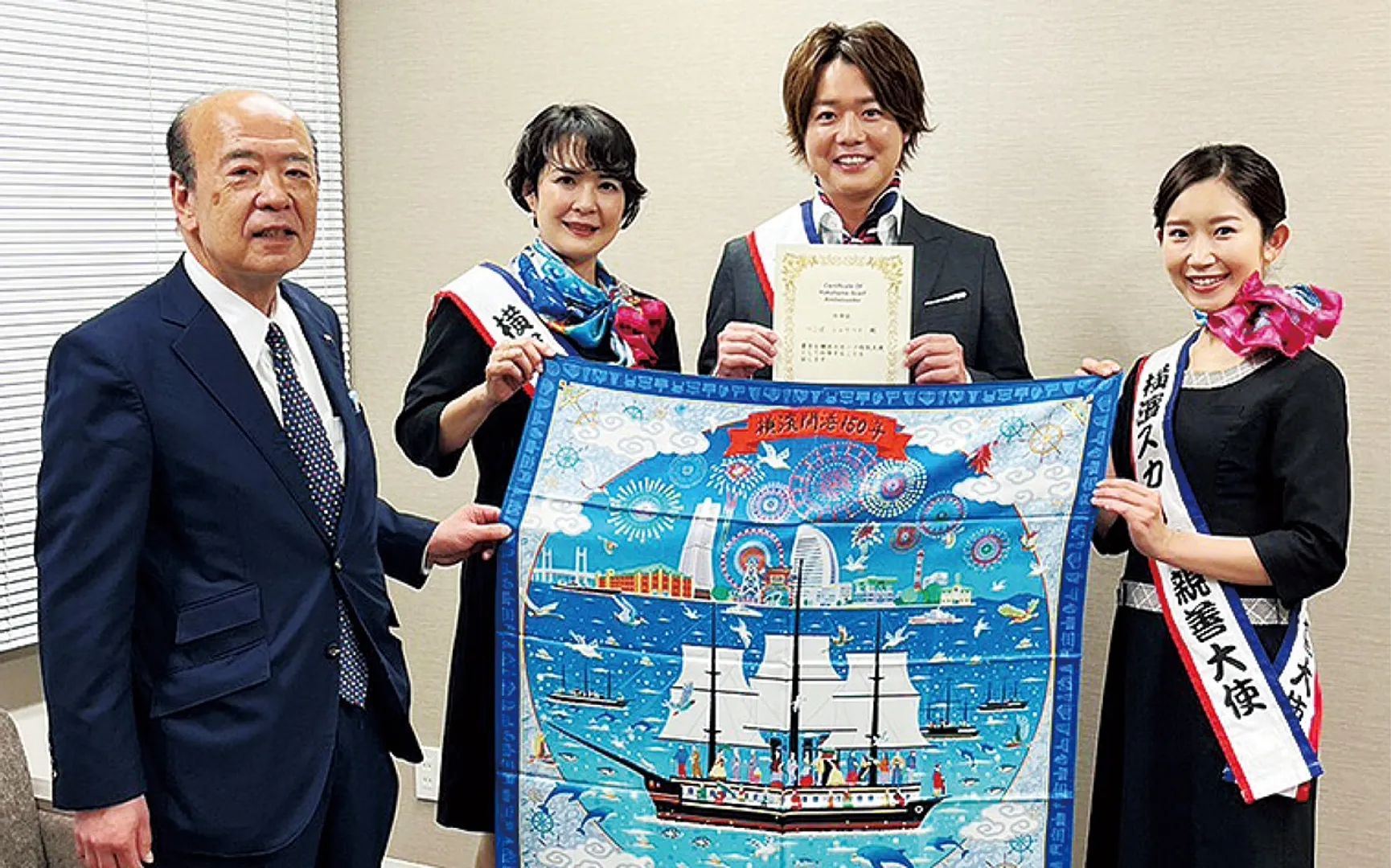 就任式で横浜繊維振興会の松村俊幸会長（左）から任命証が手渡された。昨期の大使と共に