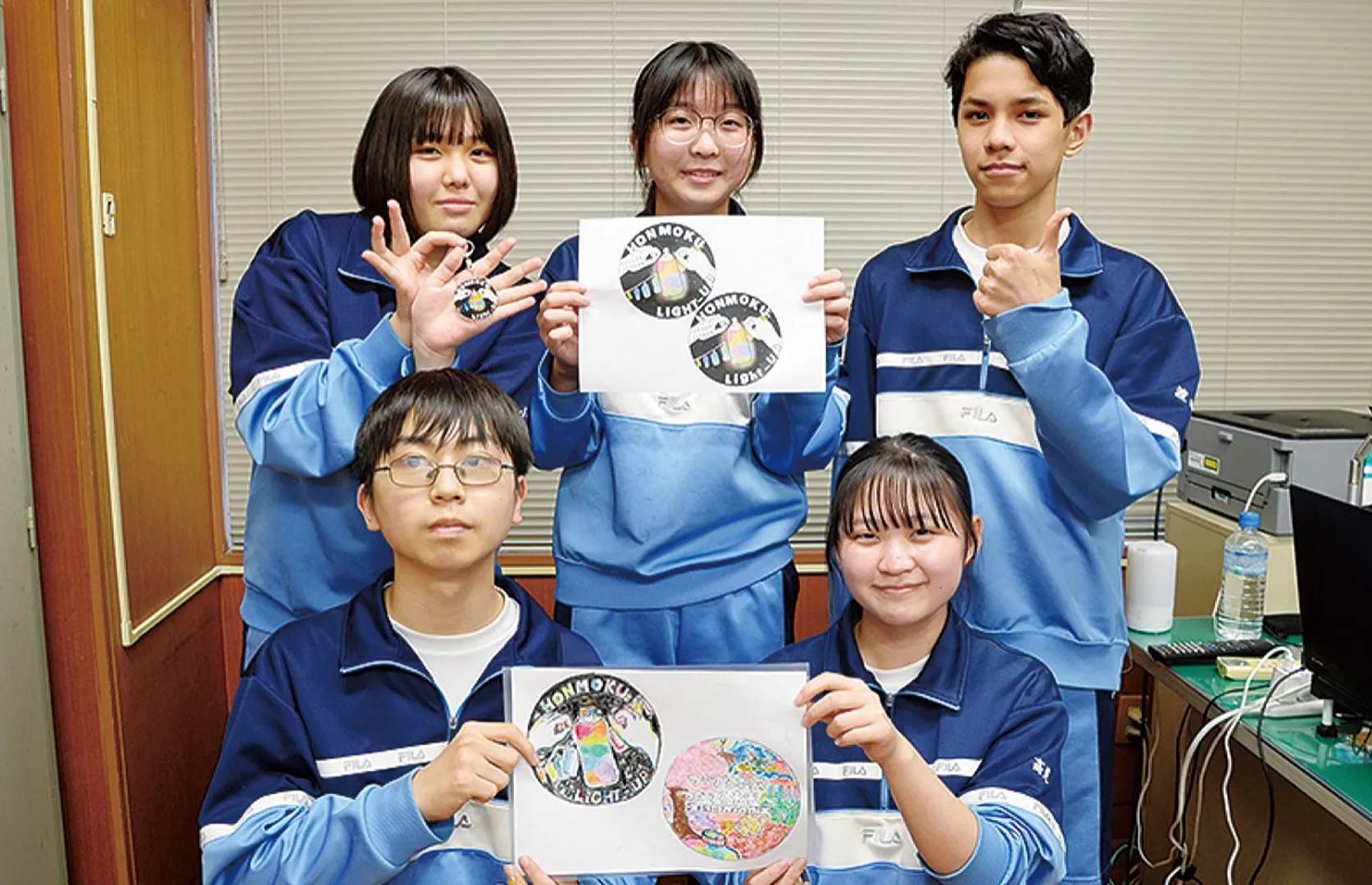 商品の原画を持つ生徒ら