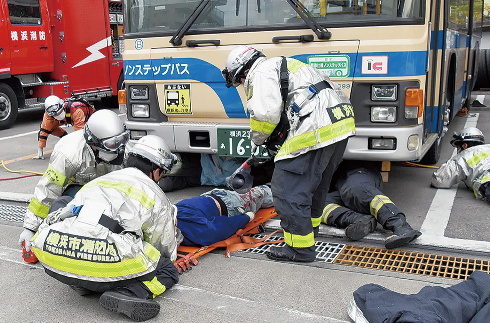 車両の下から人（人形）を助け出す消防隊員