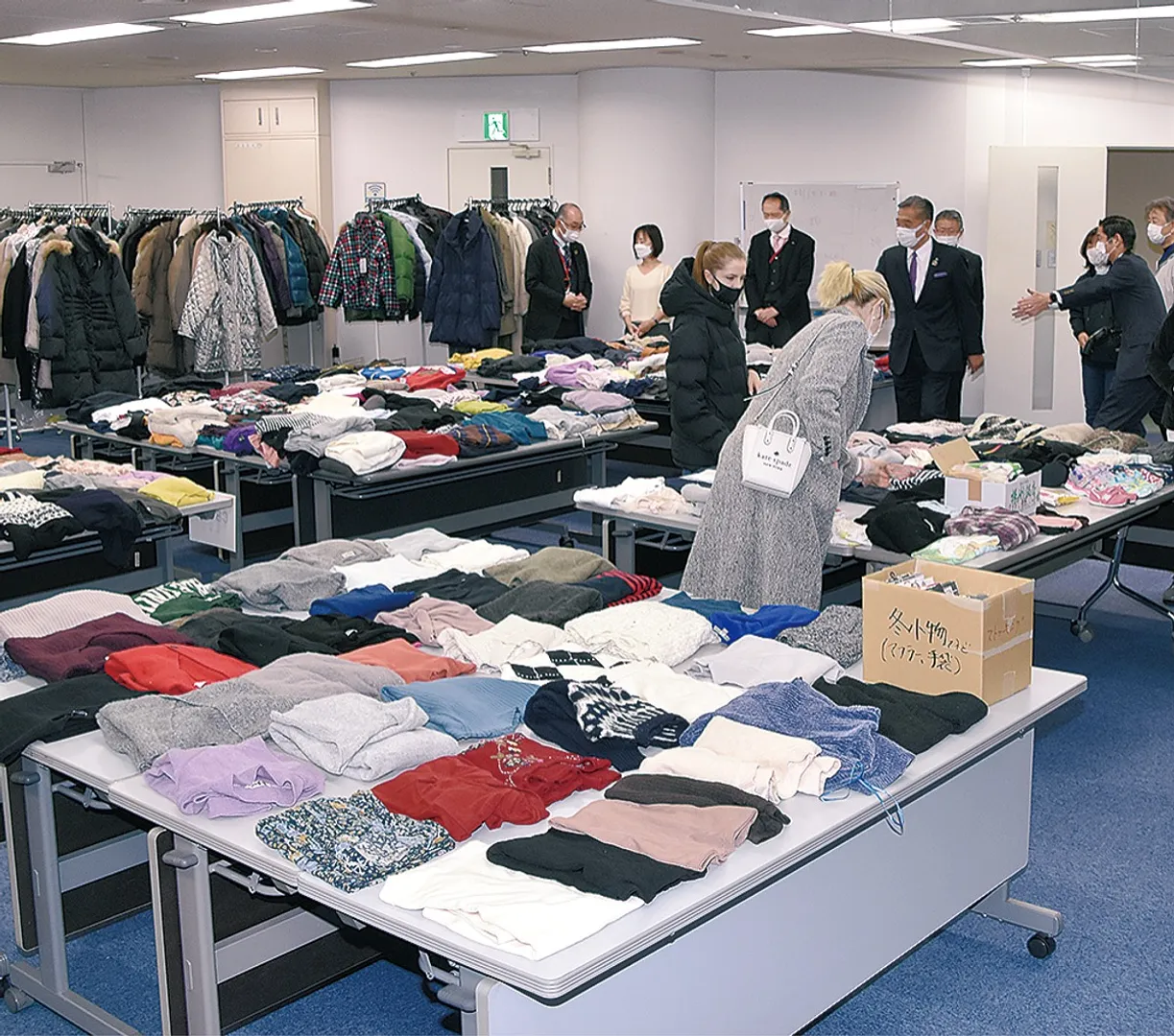 会場に並んだ衣類を見るウクライナの人たち