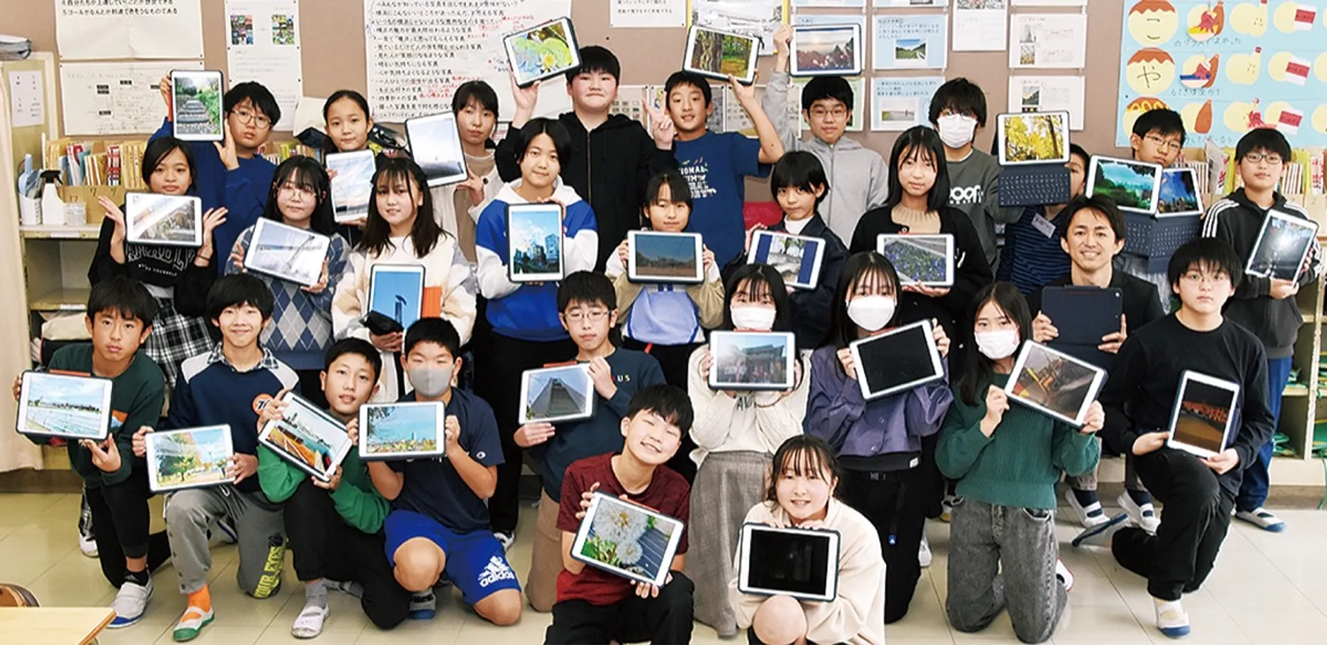 撮影に使ったタブレットを手にする６年４組の児童たち