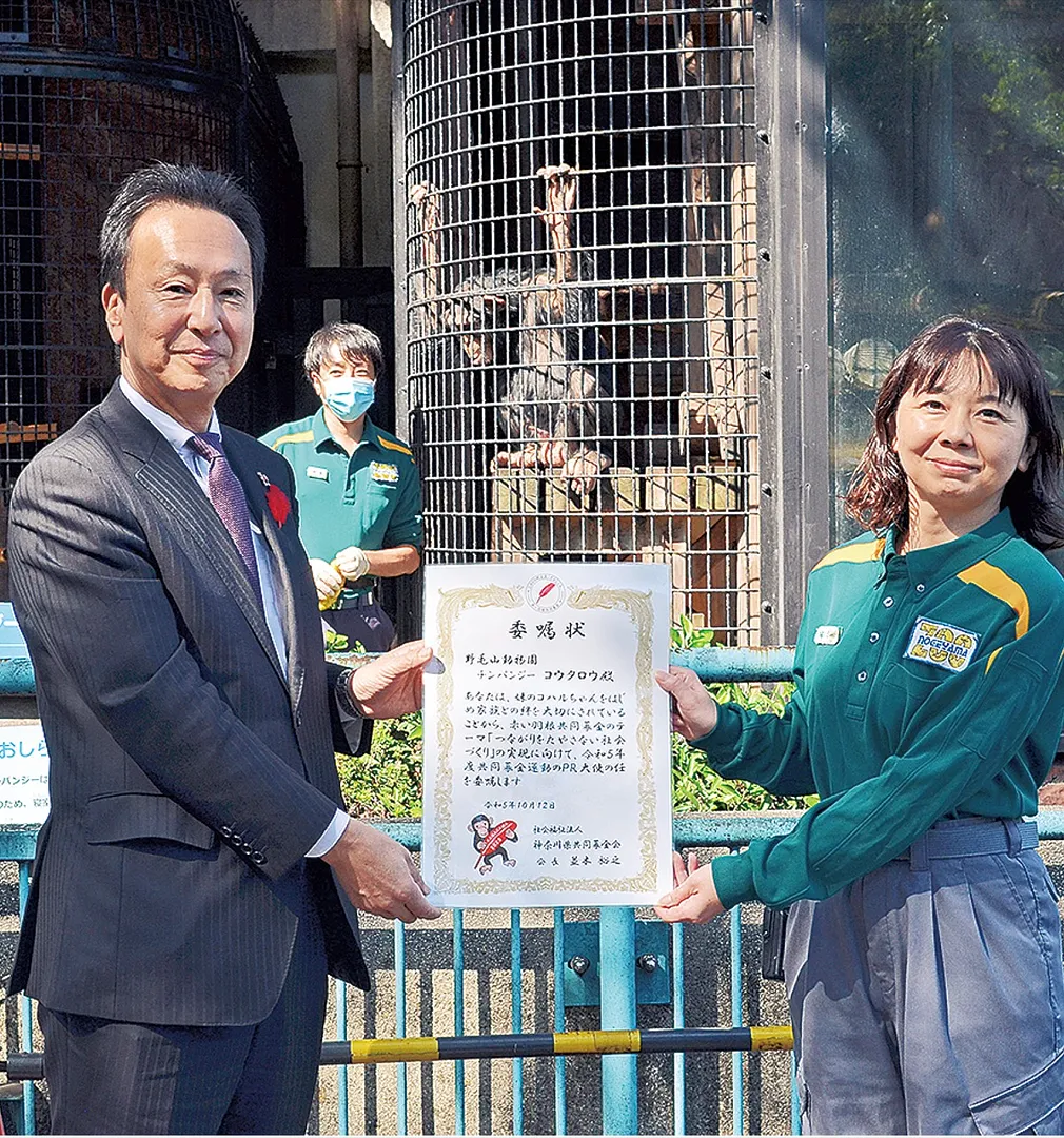 ｢コウタロウ｣の獣舎前で委嘱状を受け取る田村園長（右）