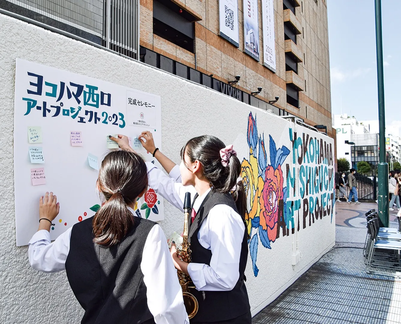 ビブレ前の橋上に描かれた壁画。来街者がアートの感想をボードに寄せていた＝10月21日