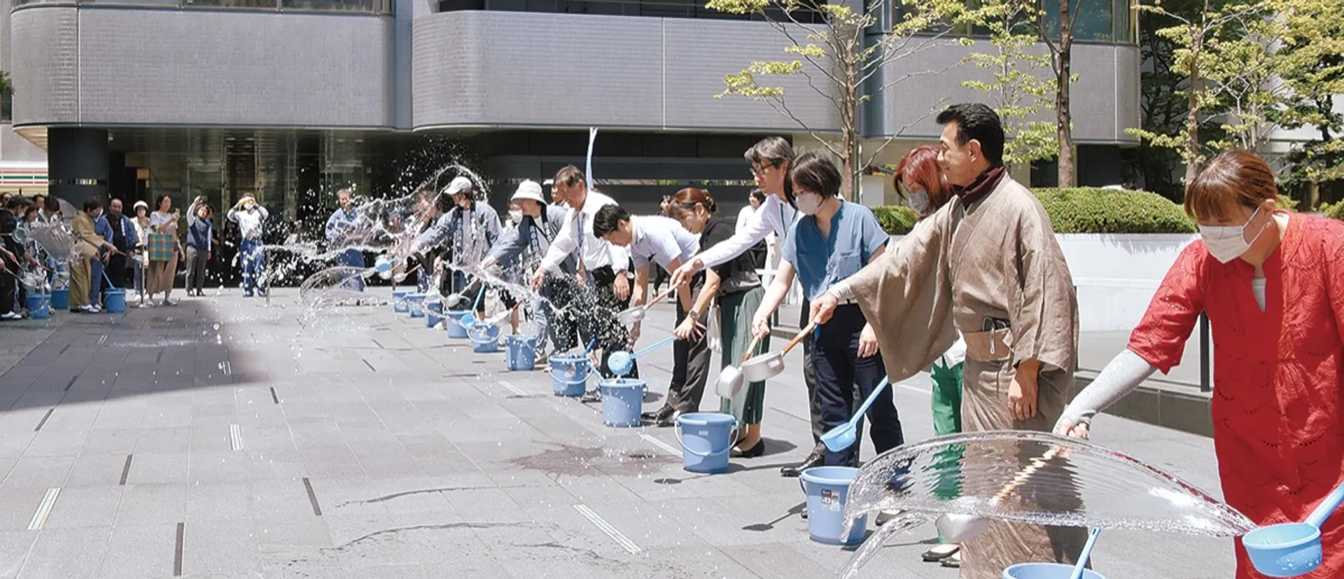 一斉に水を撒く参加者たち