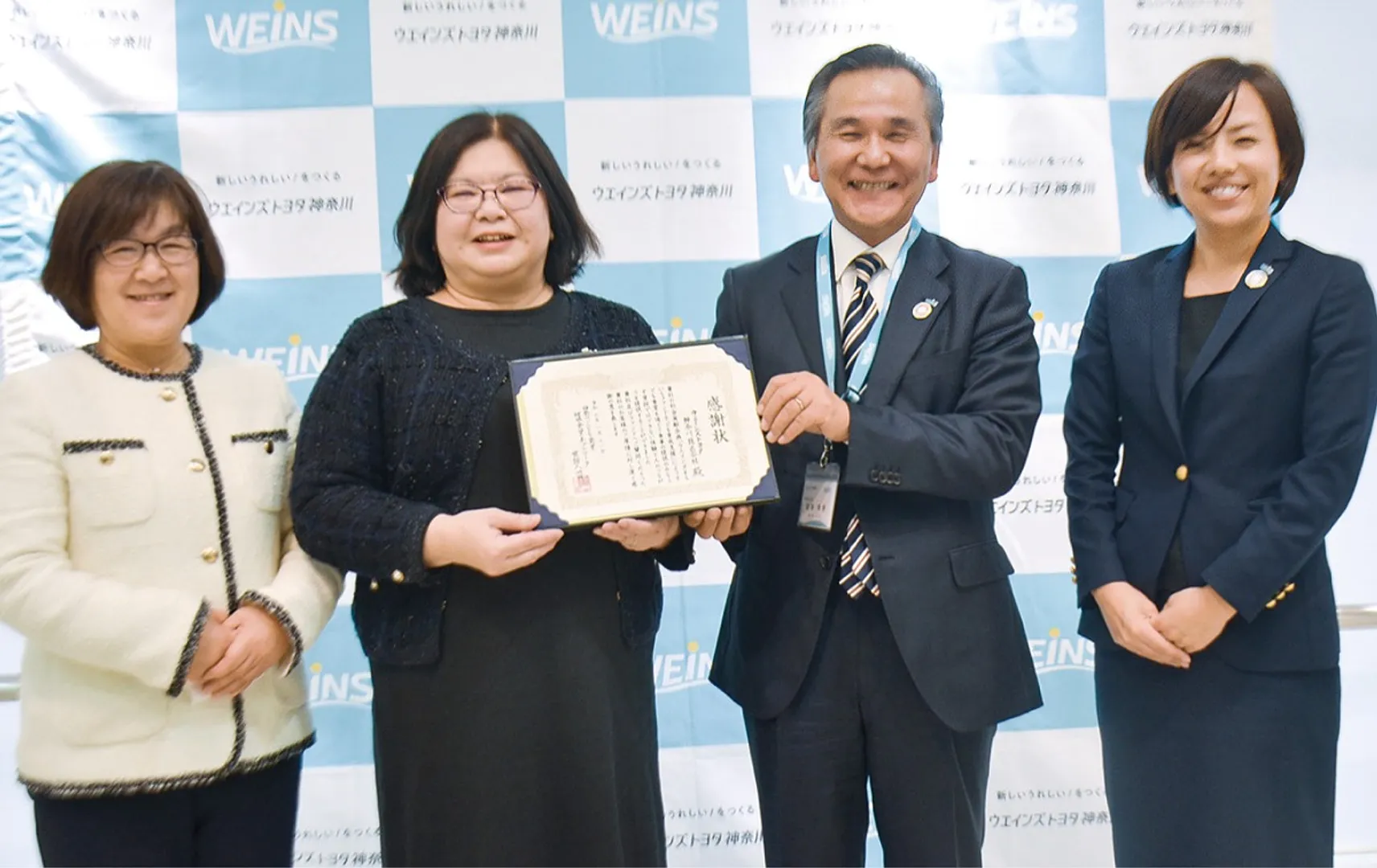 感謝を手に梨本専務（中央右）と佐藤さん
