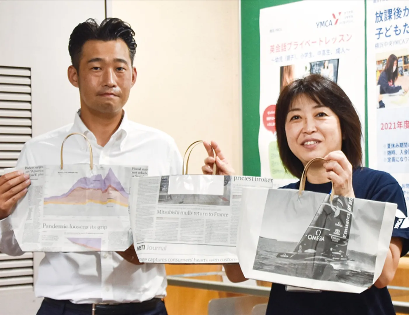 特製のフードパントリーバッグを手にするＹＭＣＡ職員（右）と横浜ＲＣの担当者