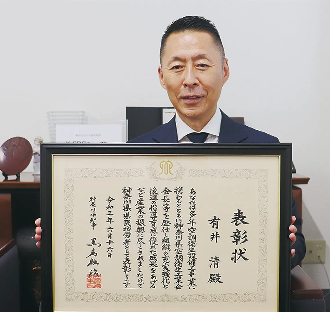 表彰状を持つ有井さん