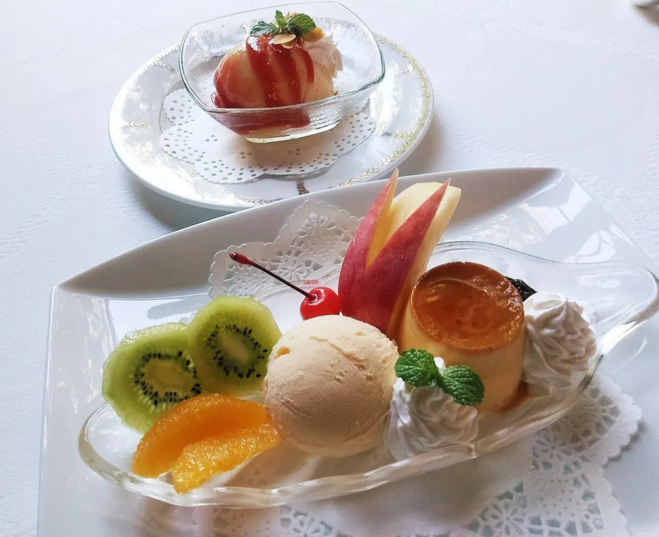 これぞ王道のプリンアラモード！奥がバニラアイスの上に桃のコンポートを乗せ、ラズベリーソースをかけたピーチメルバ