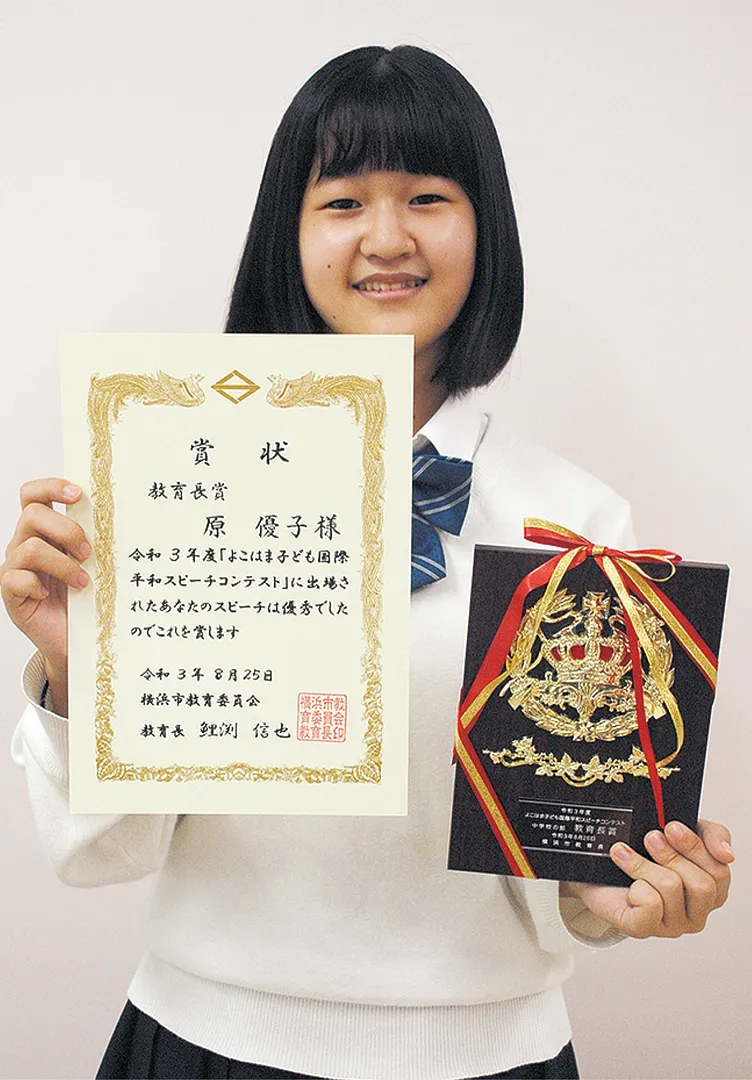 賞状と盾を手にする原さん