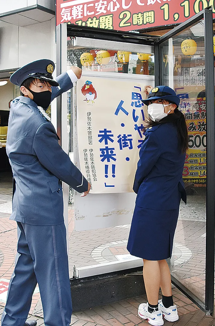 イセザキ・モール入口にポスターを掲示する中学生