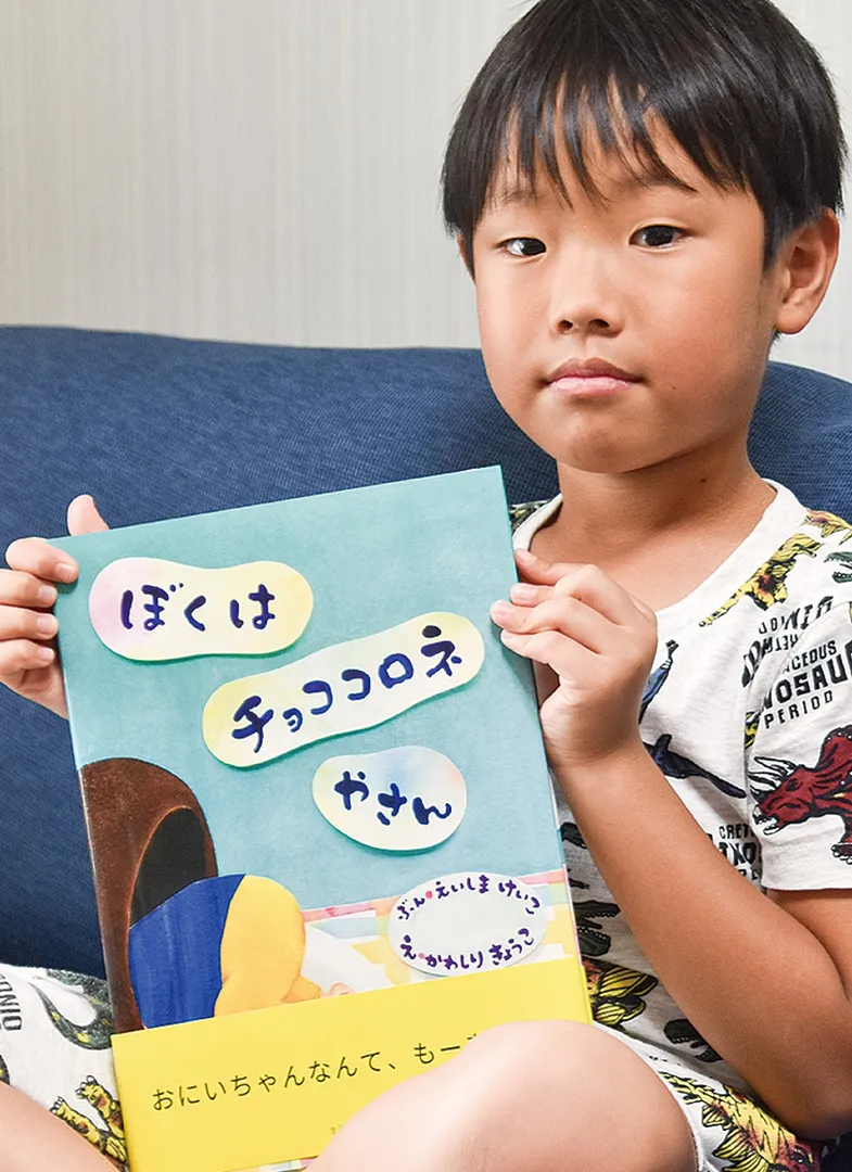完成した絵本を手にする一歩さん